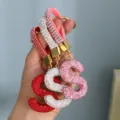 Close-up detail of full rhinestone S-letter keychains in red, silver, and pink - Pink Rhinestone S