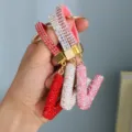 Detail showing sparkling rhinestone-encrusted alphabet keychains in multiple colors - Initial V Style / Pink