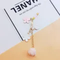 Detailed view of personalized flower and pom-pom charm with H letter for bags - Cherry Blossom Phone Strap