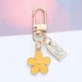 Detail shot of a yellow daisy flower keychain featuring a 'Hand made' metal tag - Daisy Pendant (With Hand Made Tag) / Yellow