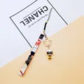 Japanese maneki-neko lucky cat phone strap with gold sakura charm and traditional bell - Independent OPP Bag Packaging / Black