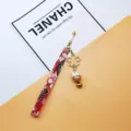 Japanese lucky cat phone charm with red floral strap and golden sakura bell pendant. - Independent OPP Bag Packaging / Pink