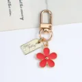 Red flower daisy keychain with a gold metal clasp and a hand made tag pendant - Daisy Pendant (With Hand Made Tag) / Red
