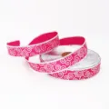 Vista detallada de cinta navideña fucsia de 5 cm con patrones de espiral plateados - Rosa rojo