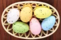 Close-up view of colorful speckled foam Easter eggs arranged in a beige lattice basket - Style 9