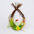Detail shot of an Easter egg twig wreath with a chicken, colorful eggs and flowers. - Style 6