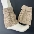 Detailed shot of beige knitted wool leg warmers with vertical stripes and soft cuff design. - Light Camel