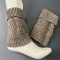 Detailed view of merino wool knit leg warmers featuring vertical stripes and cozy slouch design. - Brown/Grey