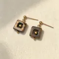 Detalle de pendientes cuadrados de ojo de tigre con pernos de acero dorados - Ojo de tigre