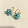 Nahaufnahme böhmischer Türkis-Blumenohrringe mit polierten, goldfarbenen Edelstahl-Creolen - Türkis
