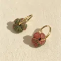 Nahaufnahme der böhmischen Naturstein-Blumen-Creolen aus goldfarbenem Edelstahl - Unakit