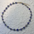 Detailed view of blue marble stone beads and gold stainless steel on a beaded necklace - Necklace / Blue Spot Stone