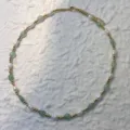Detail view of natural freshwater pearl and green stone necklace on textured background - Green Aventurine - Necklace
