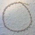 Close-up of irregular natural rose quartz stones and gold-plated beads on a necklace - Necklace / Rose Quartz