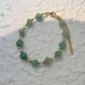Detailed view of the green stone beads and gold-tone chain on the bracelet - Bracelet / Green Aventurine