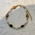 Detail view of a handmade bracelet with freshwater pearls and natural brown stones. - Tiger Eye - Bracelet