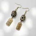 Detail shot of vintage stainless steel earrings with natural dalmatian stone and eye motifs - Spotted Stone