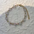 Detail view of beaded bracelet with frosted stones and pink beads on white texture - Bracelet / Rose Quartz