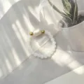 Detailaufnahme eines handgefertigten elastischen Rings mit Barockperle - Weiß