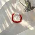 Macro view of red faceted glass beads and white shell fish charm on elastic ring - Shell Fish (Stretch) / Red