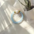 Detailansicht eines handgefertigten hellblauen Glasperlenrings mit weißer Süßwasserperle - Seeblau
