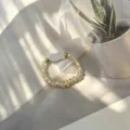 Detail view of handmade champagne glass beaded elastic ring with white shell fish charm - Shell Fish (Stretch) / Yellow