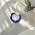 Detailed view of handmade blue glass bead elastic ring with white shell fish charm - Shell Fish (Stretch) / Blue