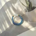 Detail view of handmade beaded elastic ring with blue glass beads and shell fish charm - Shell Fish (Stretch) / Aqua