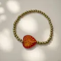 Detailansicht des roten Herzanhängers mit strahlendem goldfarbenem Muster - Radiating love-red