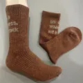 Detailed close-up view of 50% merino wool hiking socks in brown with knit quote text. - 36-40 / Brown