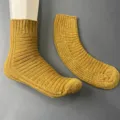 Detail view of mustard yellow women's mid-tube merino wool socks featuring a fine ribbed knit. - 36-40 / Ginger Yellow