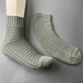 Detail view of women's grey-green ribbed knit mid-tube socks, showcasing texture and shape. - 36-40 / Gray Green