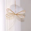 Close-up of golden wire dragonfly suncatcher with crystal bead tail against a soft background - Dragonfly Style