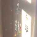 Detalle de un atrapasol de cristal con forma de hongo creando arcoíris de prisma. - Cristal de roca
