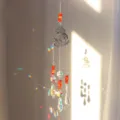 Detalle de un atrapasueños de cristal de hongo que refleja patrones de arco iris - Ágata roja