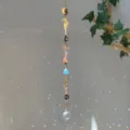 Close-up of crystal suncatcher with natural stones and witch hat charms in sunlight - Sun Witch Hat Black Stone Style (GF04) / 71-81cm