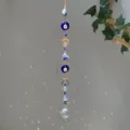Bohemian crystal suncatcher with evil eye beads and raw stones hanging in sunlight - Evil Eye Blue Stone Style (GF03) / 71-81cm