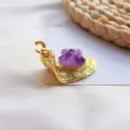 Detailopname van een gouden slakkenbeeldje met een natuurlijke paarse amethistkristal - Amethist Slak Ornament (Gouden Basis) / 5-6cm