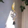 Nahaufnahme eines goldenen Mondgesicht-Sonnenfängers mit Kristall und schwarzem Stein - Obsidian-Stil / 28cm