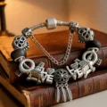 Primo piano di bracciale con ciondoli argento con Torre Eiffel e LOVE su libri vintage - 16cm / Stile Torre Acchiappasogni Retro (Z-011)