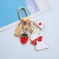 Detailed view of a golden keychain with cute white rabbit, strawberry, and ace of hearts charms - Single OPP Bag Packaging / Bowtie Rabbit Strawberry Ace of Hearts