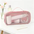 Vista dettagliata di una borsa rosa in rete con asciugacapelli e vari accessori - Rosa