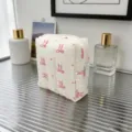 Detailed view of the quilted cream makeup bag with cute pink bow pattern on glass - Heart Pattern Bow