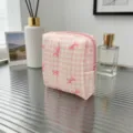 Pink gingham quilted makeup bag with red bow patterns on a stylish glass table - Plaid Pink Bow