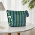 Detailansicht einer gestreiften PVC-Kosmetiktasche mit einer dekorativen Quaste. - Dünne Blau-Grüne Streifen
