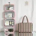 Vue détaillée de la trousse de toilette pliante à rayures roses et vertes avec 4 compartiments. - Rayures vertes et roses