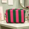 Vista detallada del neceser de pana a rayas sobre un tocador de maquillaje - Rayado Verde Y Rosa Rojo