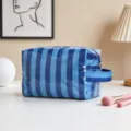 Primer plano de bolsa de maquillaje a rayas azules de gran capacidad con asa para viajes - Rayas Finas Azul Real