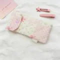 Detalle del patrón floral y la hebilla de corazón en este estuche acolchado rosa. - Rosa y Blanco