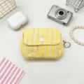 Detailed view of a yellow tweed mini coin purse with a button flap and ring zipper pull. - Yellow